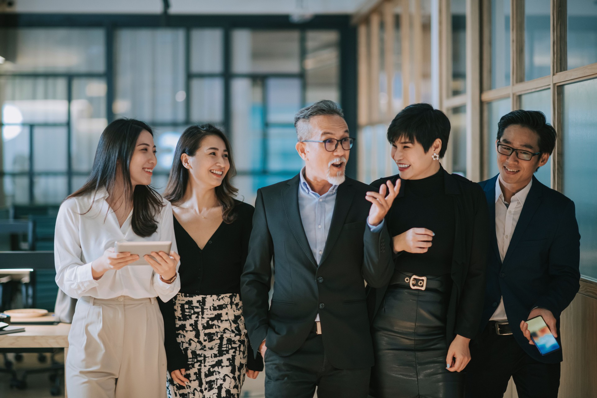 group of asian chinese successful office management team having discussion while walking toward camera